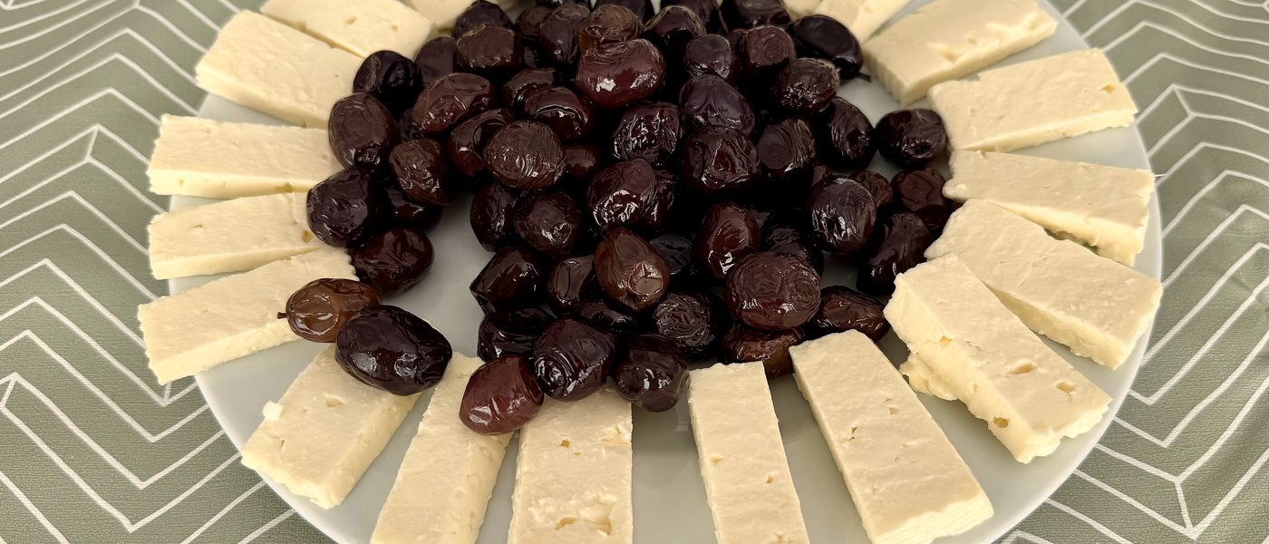 Tabakta beyaz peynir dilimleri ve siyah zeytin
